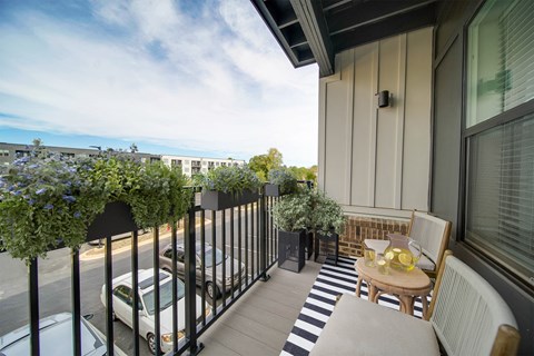 a balcony with a table and chairs and a view of the ocean