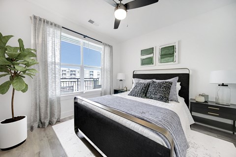 a bedroom with a bed and a large window