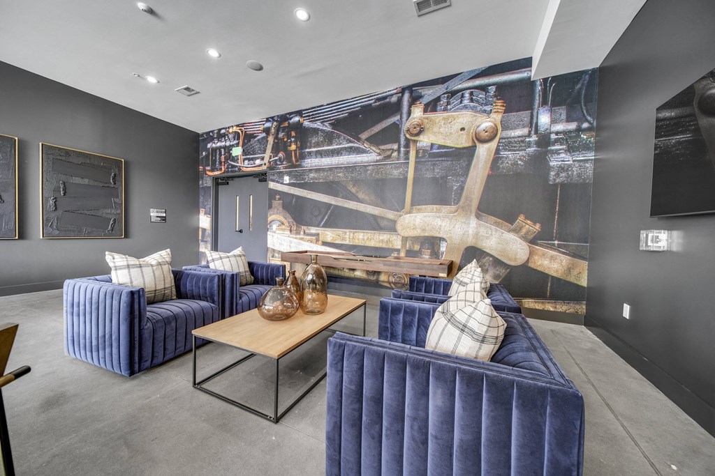 a living room with blue couches and a wall mural of a boat