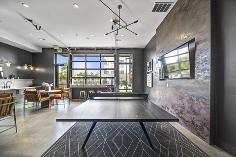 a game room with a ping pong table and a window