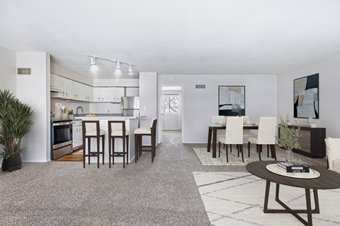 A modern kitchen with white cabinets and a dining table set with chairs.