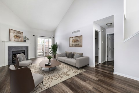 A living room with a fireplace, two couches, a coffee table, and a rug.
