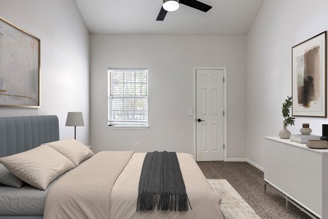 A bedroom with a bed, a window with blinds, a ceiling fan, and a nightstand with a plant on it.