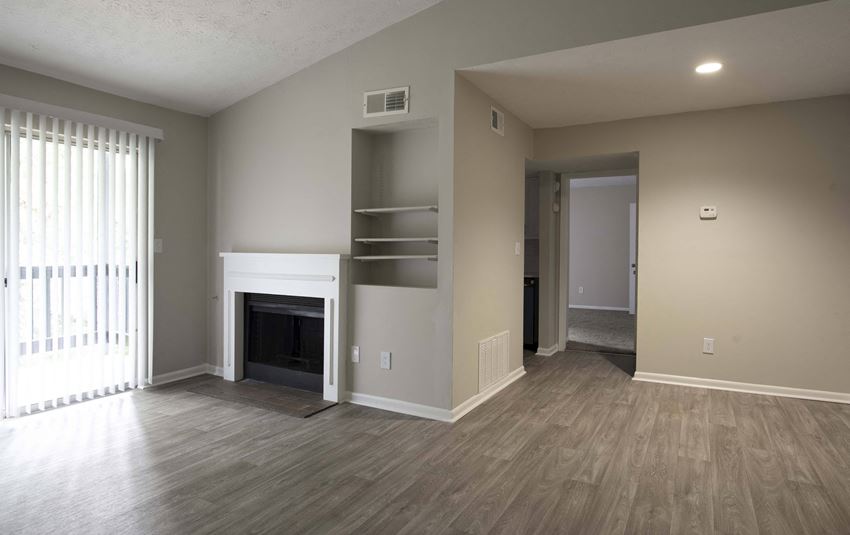 a living room with a fireplace and wooden floors