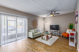 Spacious living space featuring wood like flooring and ceiling fan  at The Essex, Altamonte Springs, FL, 32701