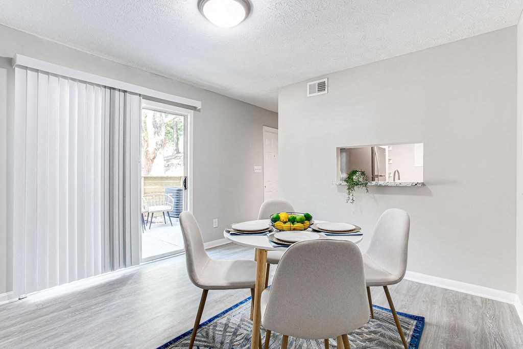 Dining area with sliding glass door leading to a patio at The Cobb Apartments-Townhomes, Austell, GA, 30168
