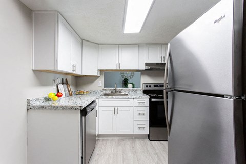 a kitchen with stainless steel appliances and white cabinets