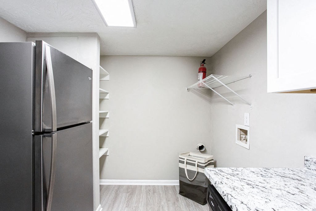 Kitchen with a refrigerator freezer next to a counter top at The Cobb Apartments-Townhomes, Georgia, 30168