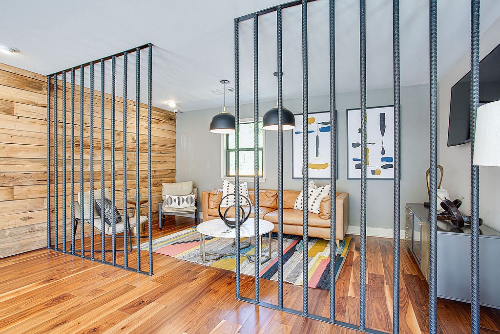 a living room with a partition with metal rods
