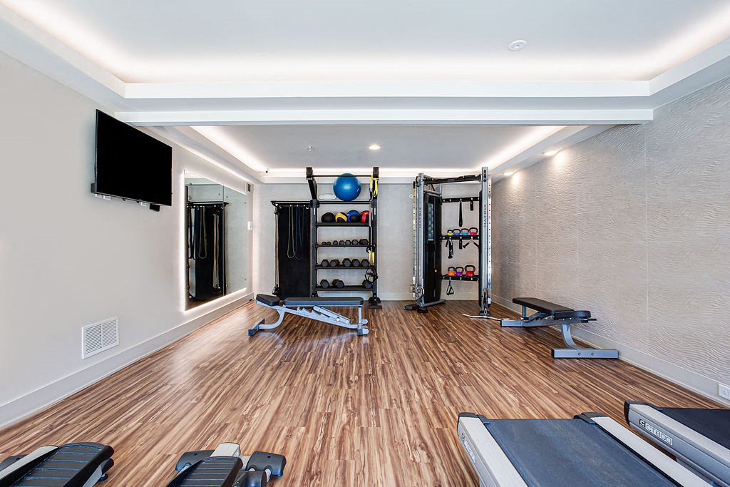 a gym with weights and a tv on the wall