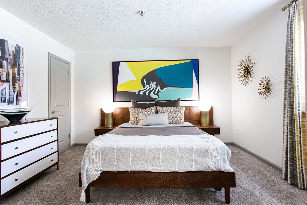 a bedroom with a bed and a painting on the wall