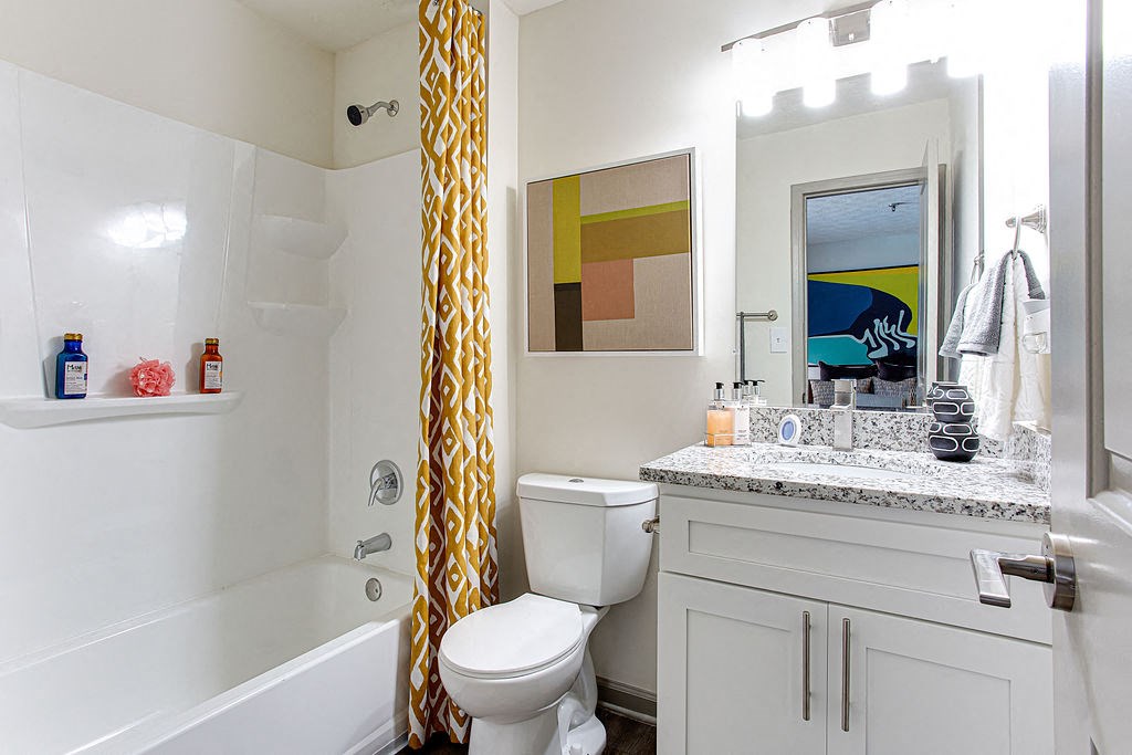 a bathroom with a yellow shower curtain and a toilet