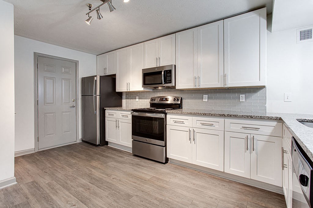 a kitchen with white cabinets and stainless steel appliances