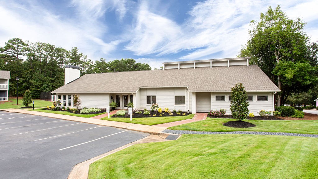 a white house with a driveway and a lawn at Magnolia Place at Stockbridge Apartments, Stockbridge, Georgia