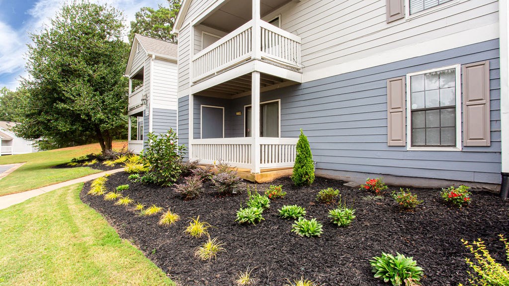 a flower garden in front of a house at Magnolia Place at Stockbridge Apartments, Stockbridge, GA