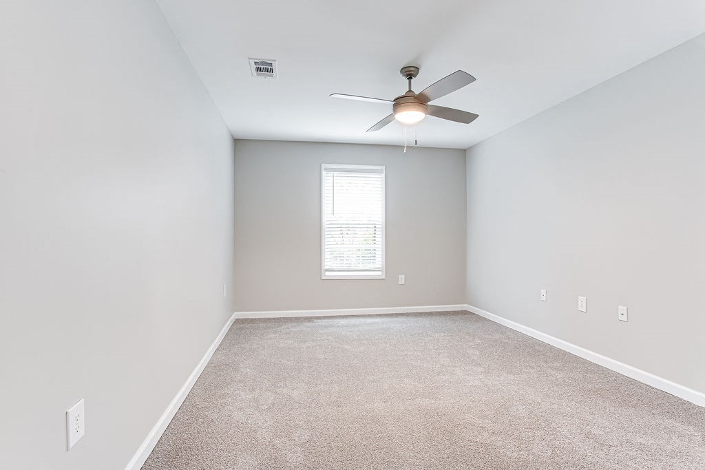 an empty room with a ceiling fan and window at Magnolia Place at Stockbridge Apartments, Stockbridge, GA, 30281