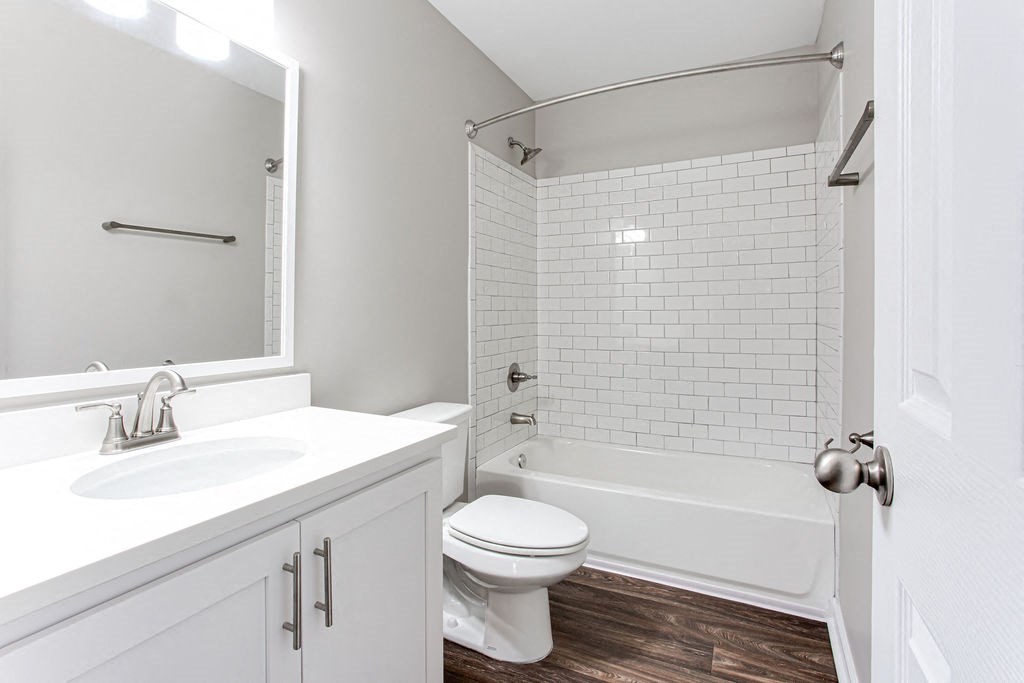 a white bathroom with a toilet and a sink at Magnolia Place at Stockbridge Apartments, Stockbridge