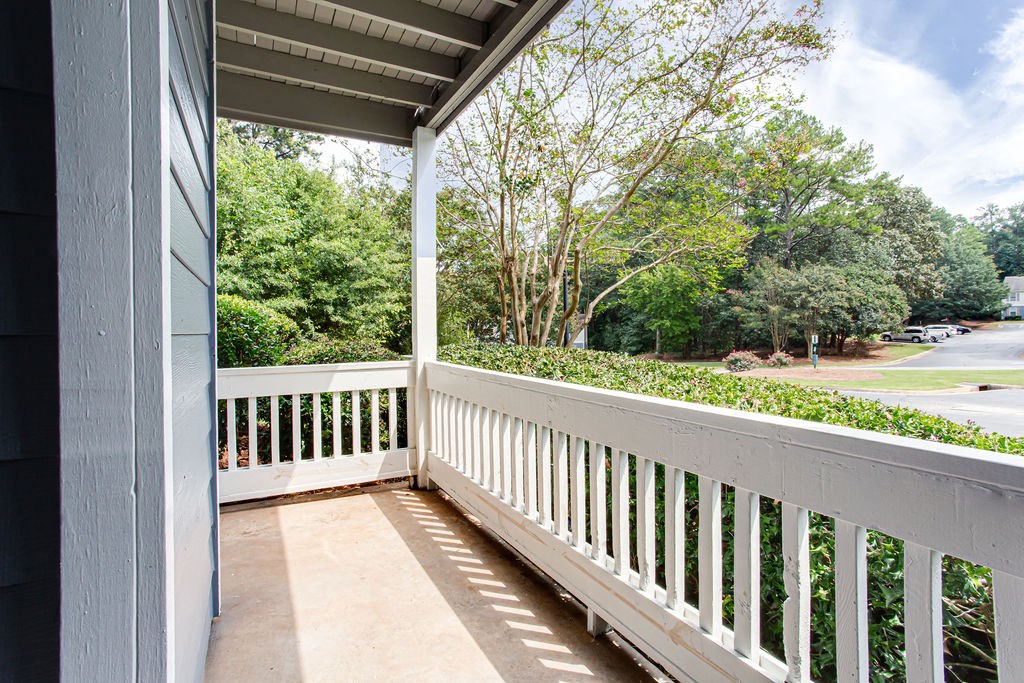 a balcony with a view of a street and trees at Magnolia Place at Stockbridge Apartments, Stockbridge, 30281