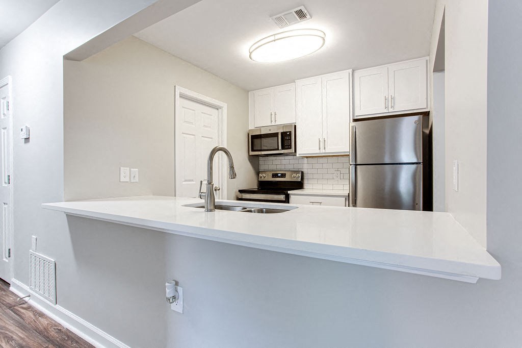 a kitchen with a counter top and a refrigerator at Magnolia Place at Stockbridge Apartments, Stockbridge, Georgia