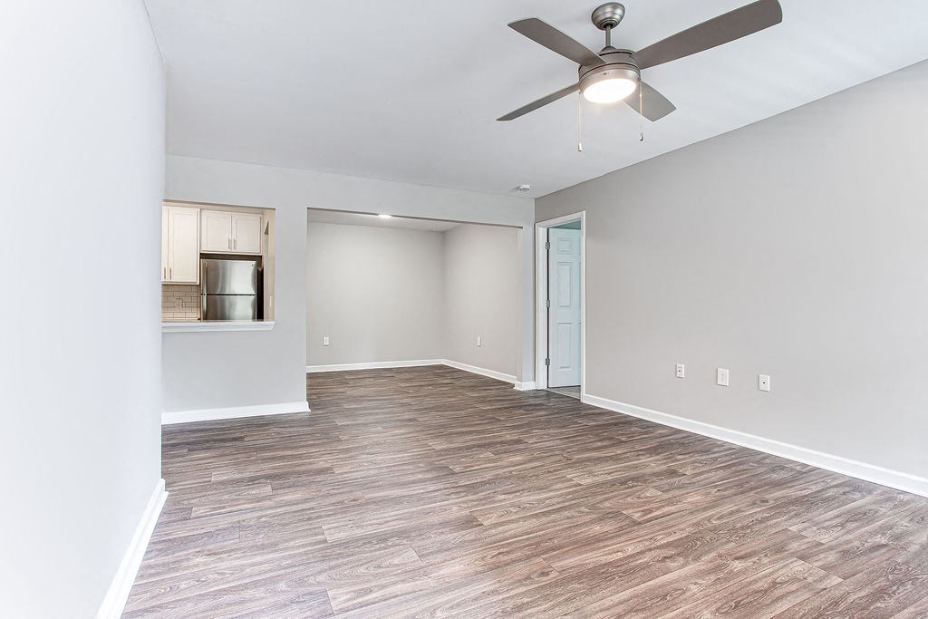 an empty living room with a ceiling fan at Magnolia Place at Stockbridge Apartments, Stockbridge