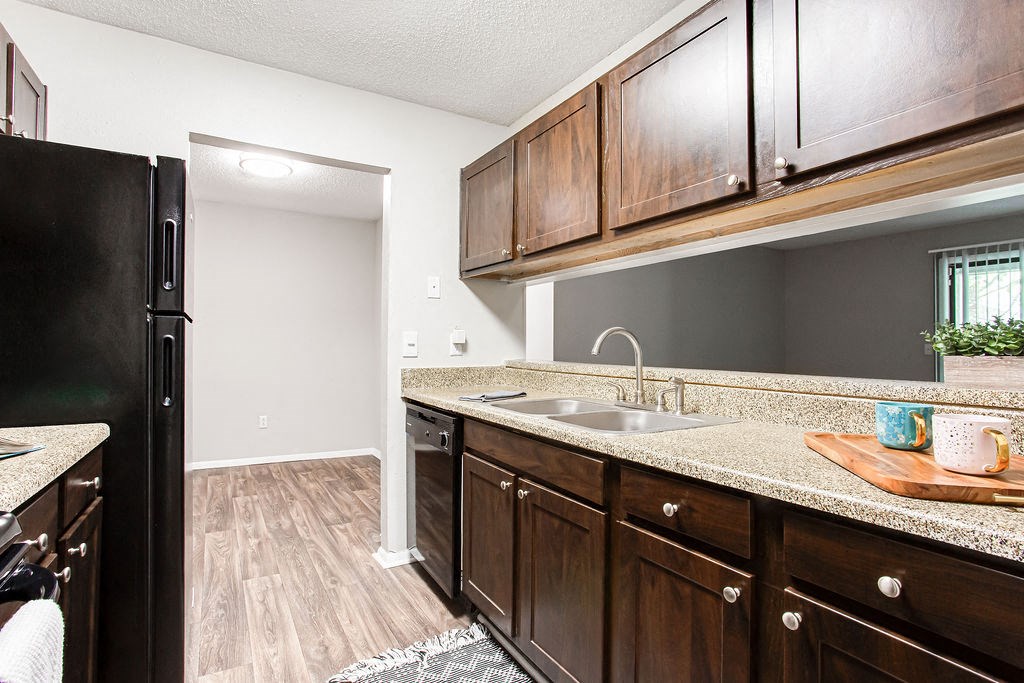 a kitchen with wooden cabinets and black refrigerator at Magnolia Place at Stockbridge Apartments, Stockbridge, 30281