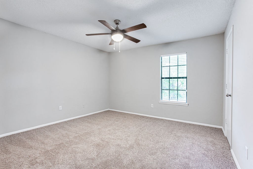 an empty living room with a ceiling fan and a window at Magnolia Place at Stockbridge Apartments, Stockbridge