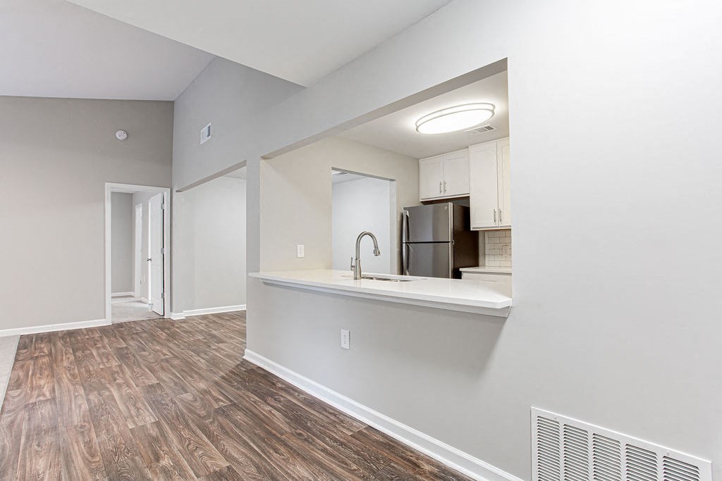 an empty apartment with a kitchen and a hard wood floor at Magnolia Place at Stockbridge Apartments, Georgia, 30281