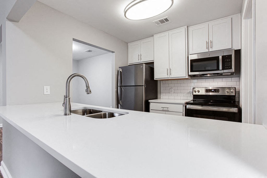 a white counter top in a kitchen with a sink at Magnolia Place at Stockbridge Apartments, Stockbridge, Georgia