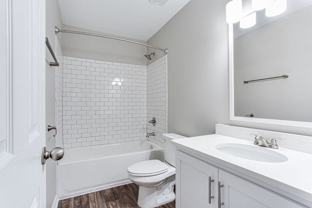 a white bathroom with a sink and a toilet at Magnolia Place at Stockbridge Apartments, Stockbridge, GA