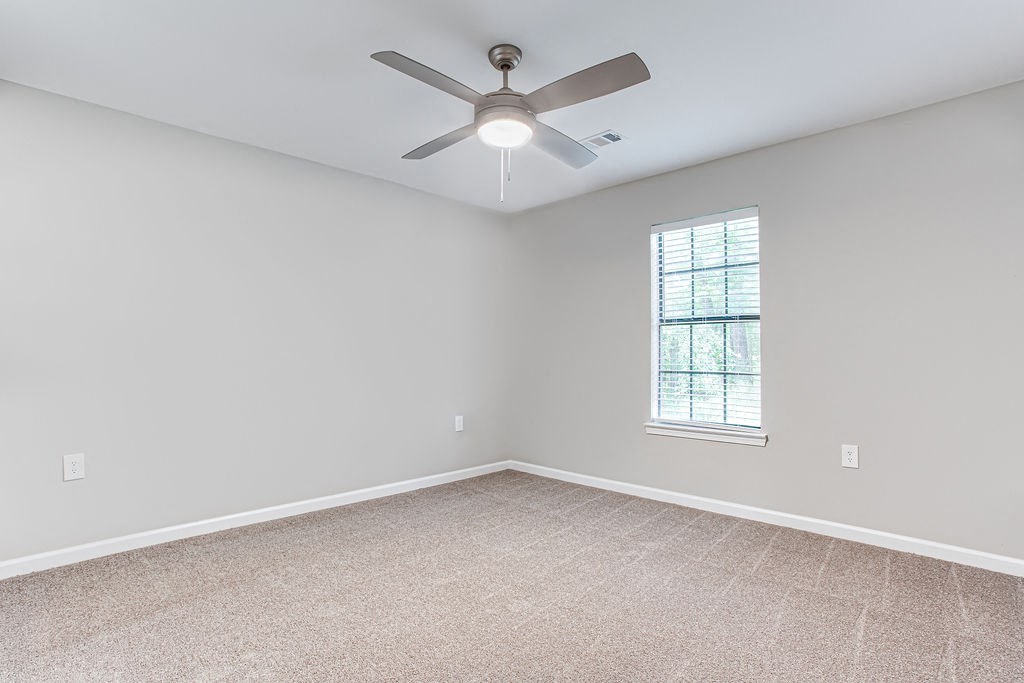 bedroom room with a ceiling fan and a window at Magnolia Place at Stockbridge Apartments, Stockbridge, 30281