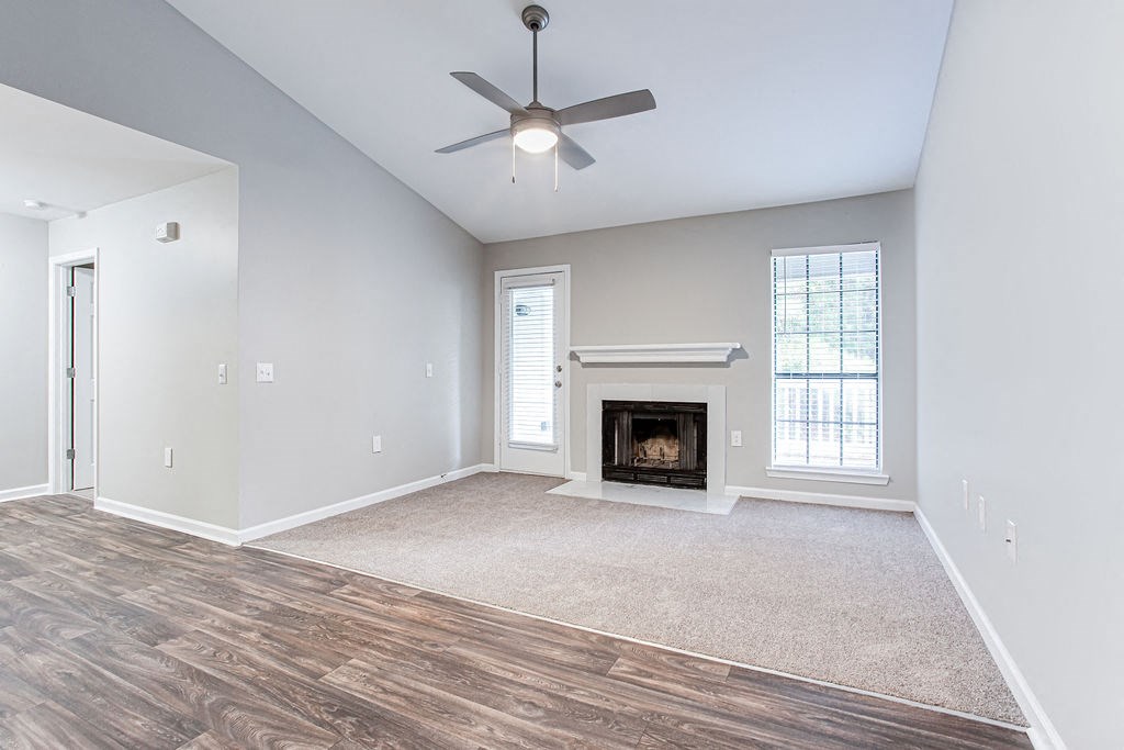 an empty living room with a fireplace and a ceiling fan at Magnolia Place at Stockbridge Apartments, Stockbridge, GA