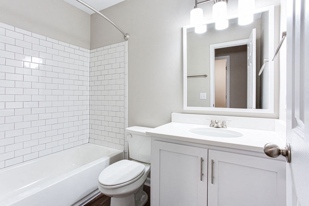 a white bathroom with a sink and a toilet at Magnolia Place at Stockbridge Apartments, Stockbridge, Georgia