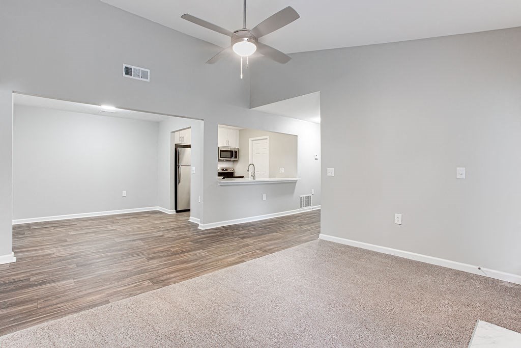 an empty living room with a ceiling fan1 at Magnolia Place at Stockbridge Apartments, Stockbridge, GA