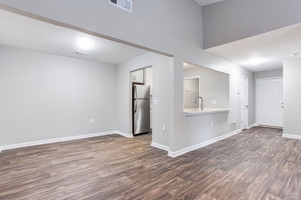 the living room and kitchen of a new home with wood flooring at Magnolia Place at Stockbridge Apartments, Georgia