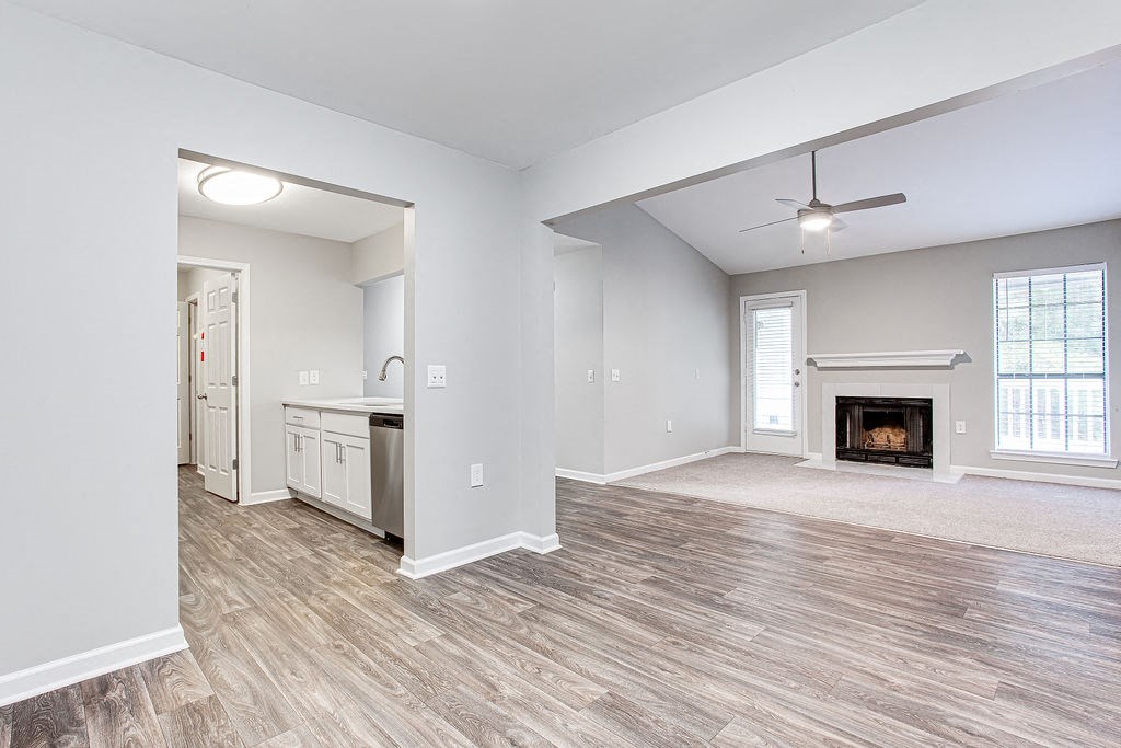 an empty living room with a fireplace and a kitchen at Magnolia Place at Stockbridge Apartments, Georgia, 30281