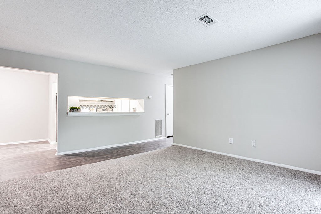 an empty living room with hard wood floors and gray walls at Magnolia Place at Stockbridge Apartments, Stockbridge, Georgia