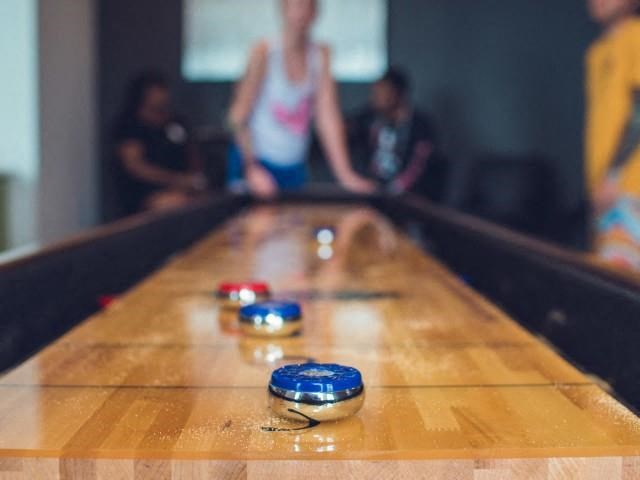 A group of people playing shuffleboard at the community clubhouse  at Lofts at South Lake, Clermont