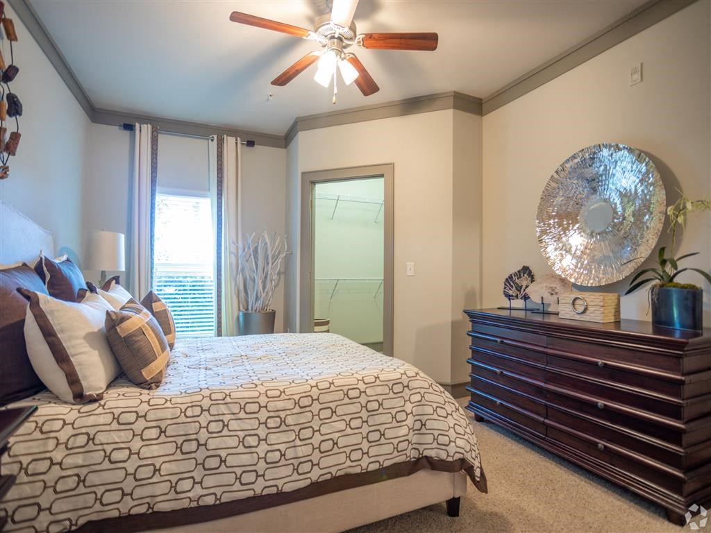 a bedroom with a large bed and a ceiling fan