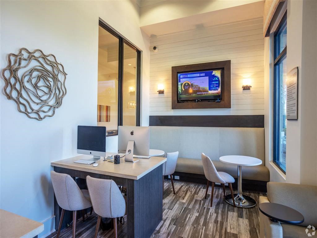 a office with two computers and a table with chairs