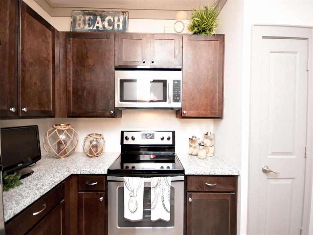 a kitchen with wooden cabinets and a stove and a microwave