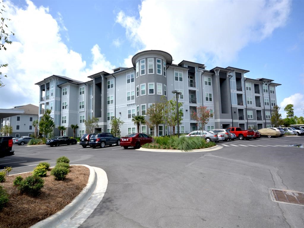 an empty parking lot in front of an apartment building