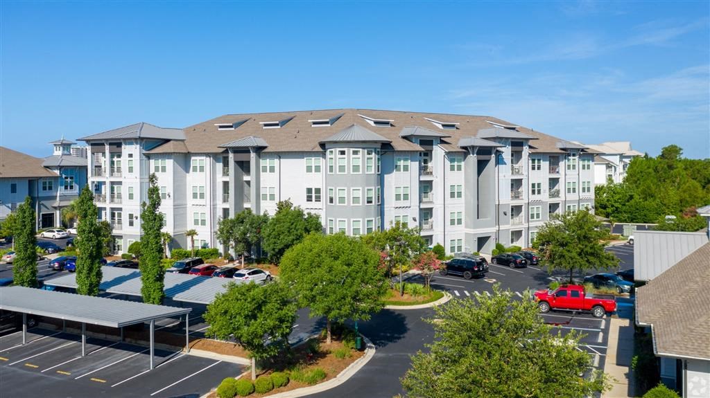 an aerial view of an apartment building with a parking lot