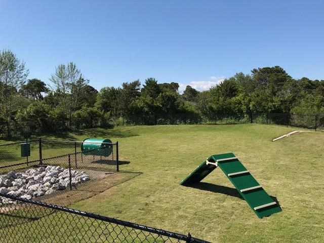 a park with a green slide in a field
