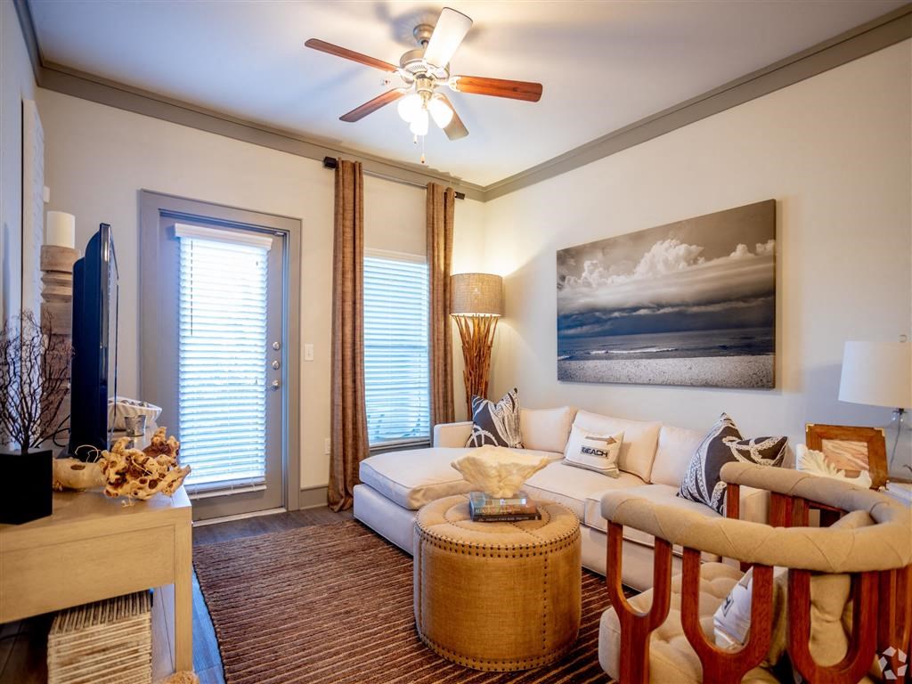 a living room with a couch and a ceiling fan