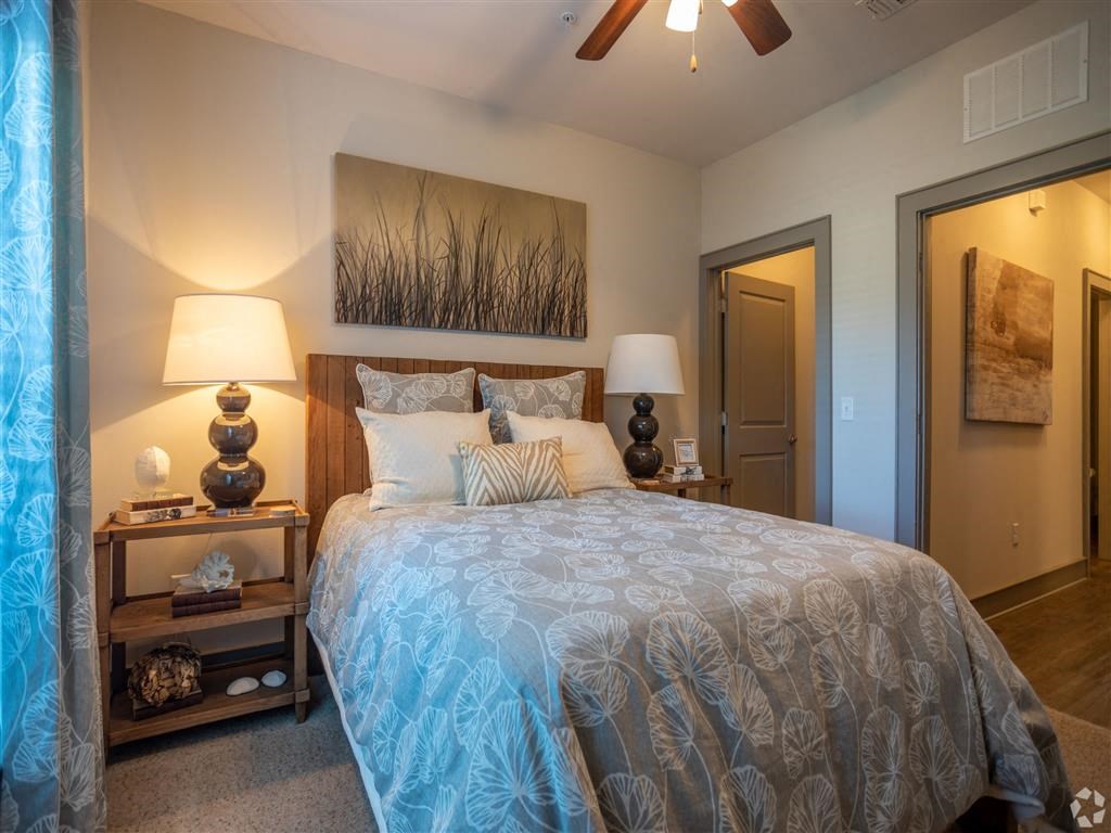 a bedroom with a large bed and a ceiling fan