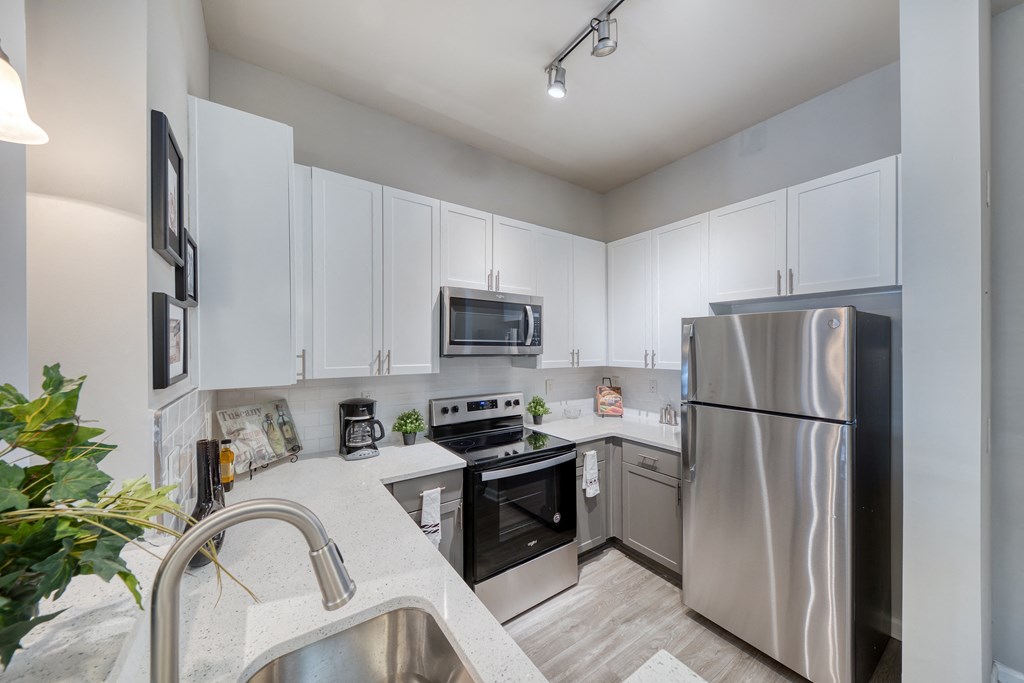 a kitchen with stainless steel appliances and white cabinets