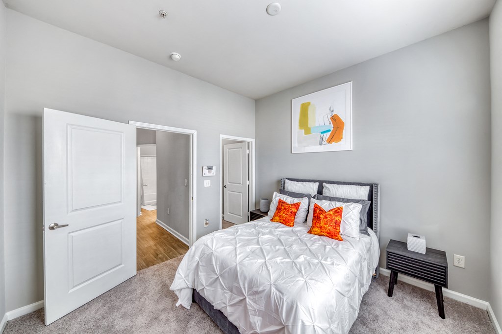 a bedroom with a bed and a door to a bathroom