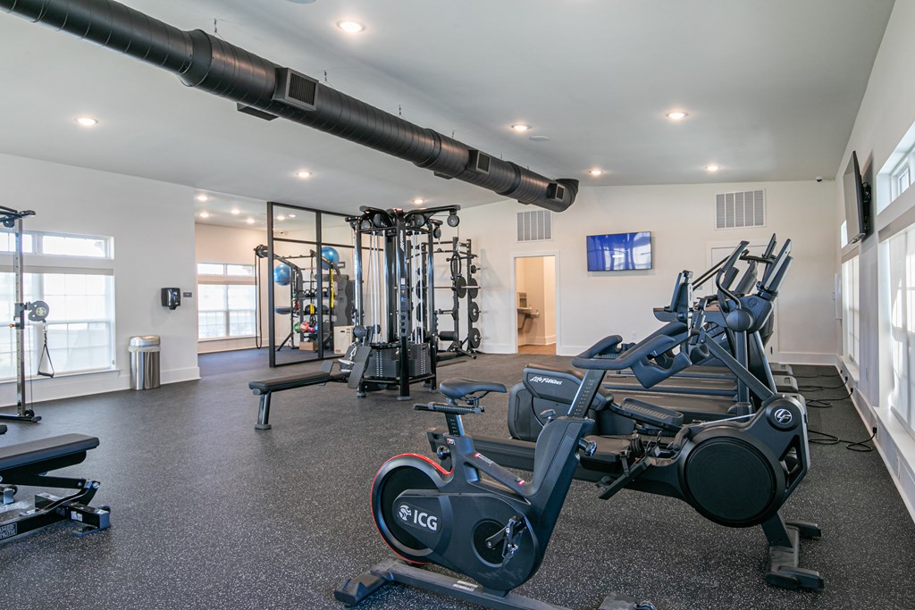 a gym with exercise machines and weights on the floor