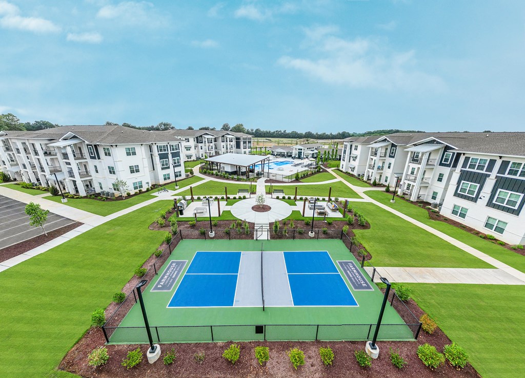 an aerial view of a pickleball court with apartments in the background