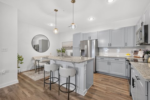 A kitchen with a bar area and a refrigerator.
